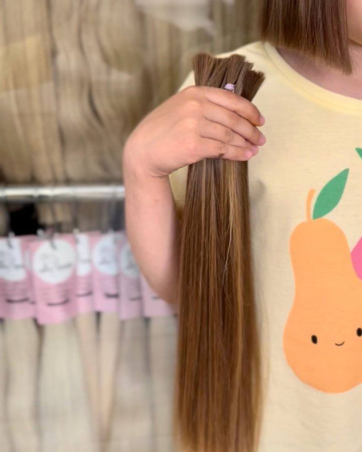 Клієнтка тримає зрізане волосся після викупу HairPrice
